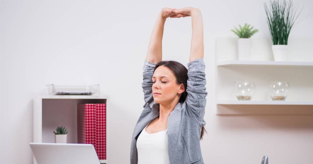 employé femme s'étire au travail 