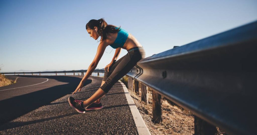 Jeune femme faisant des étirements après sa séance de course à pied