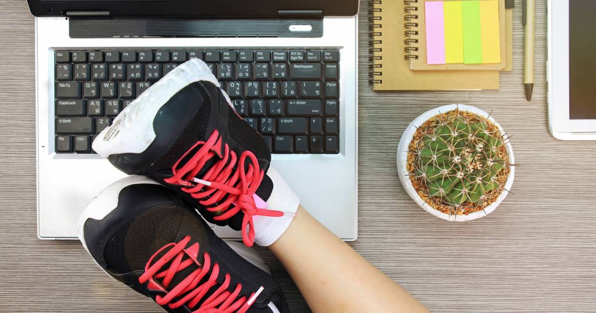 femme mettant ses baskets sur le bureau